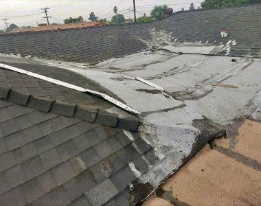 Damaged roof with a missing shingle, showing signs of wear and deterioration.