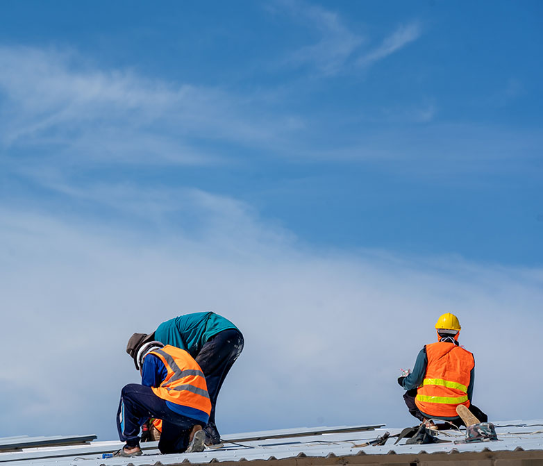 Roofers working at a metal profile roof installation