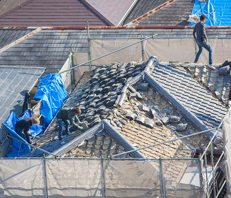 People working to tile a roof
